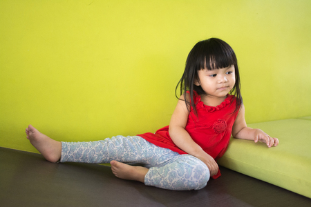 Asian little girl, sitting in a room, a child model taking picturesの写真素材