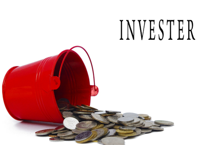 bucket spill out many coins and INVESTER text shown over white backgroundsの写真素材