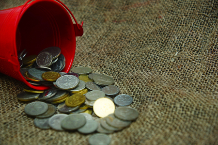 bucket spill out many coins over sackclothの写真素材