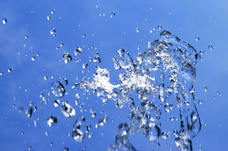 water splash over blue sky backgroundの写真素材