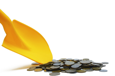 scooping coins using shovel over white backgroundの写真素材