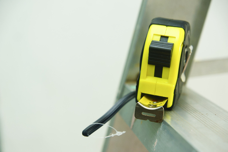 Measuring Tape On Ladder Over White Backgroundの写真素材