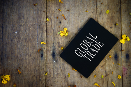 Global Trade Text On Blackboard Over Wooden Backgroundの写真素材