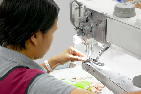Back-side Women are using a sewing machineの写真素材