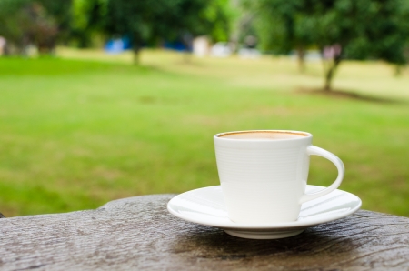 Cup of coffee on wooden table in gardenの写真素材