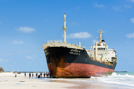 Songkhla, Thailand - March 01:Traveller sightseeing the Ships ORAPIN 4 is a liquefied natural gas tanker. The ship hit by Waves crashing ashore.On March 01,2014 at Samila Beach, Songkhla, Thailand.のeditorial素材