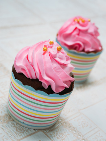 a freshly made creamy, pastel pink cupcakeの写真素材