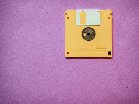 Vintage yellow floppy disk on Magenta backgroundの写真素材