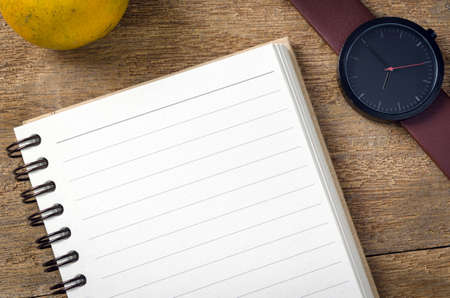 notebook with blank pages and watch on wood tableの写真素材
