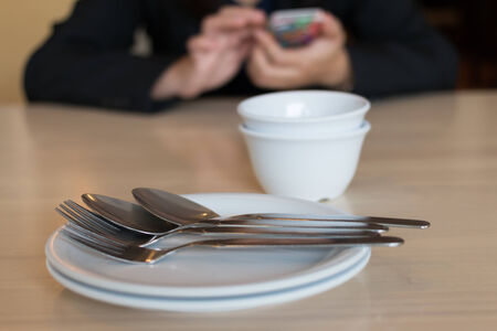 girl play smart phone on time for eatの写真素材