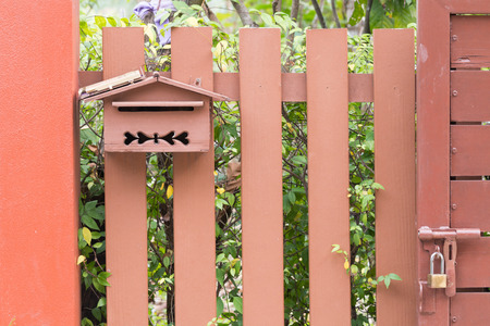 Post box on wood fence and treeの写真素材