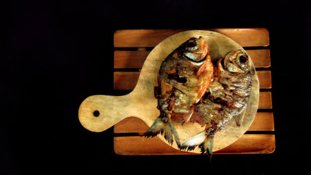 Freshwater pomfret. Served on plates and boards. Fried fish food menu. Isolated black background....