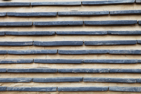 linear pattern of ancient clay and rock wall background in Koreaの写真素材