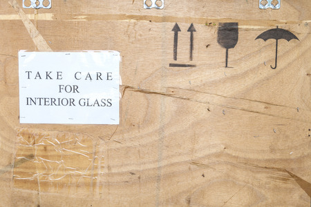 black sprayed flagile symbols and notice on brown plywood texture backgroundの写真素材