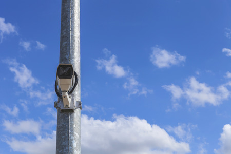 front view of single cctv on metal light pole, blue sky backgroundの写真素材
