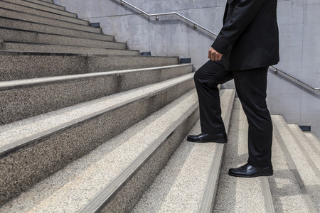 businessman is going up on large stair fight promotedの写真素材