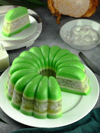 green pudding cake, sweet and chewy made from coconut and pandan leaves served on a plateの写真素材