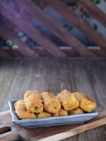 Selective focus risoles sosis mayo or mayonnaise sausage rissole rolled in breadcrumbs. it is filled with mayonnaise, boiled egg and sausage. Served on wooden plate.の写真素材
