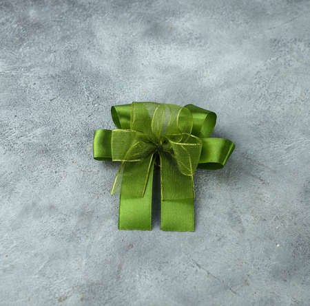 Green ribbon with a bow as a gift on a white and black backgroundの写真素材