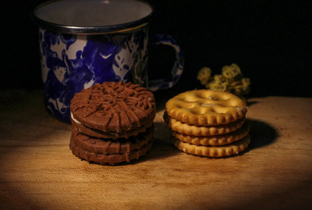 Delicious sweet chocolate cookies on a wooden table with low light