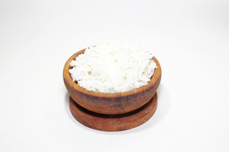 white rice in a wooden bowl on a white backgroundの写真素材