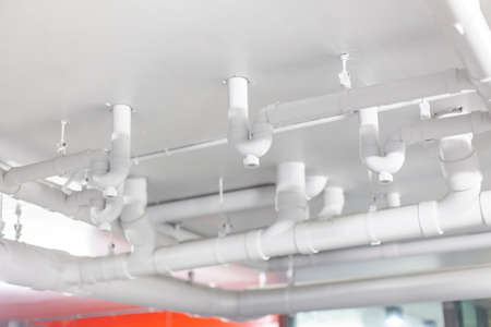 Large white water pipes inside the building. Clean modern sewage system in the building.