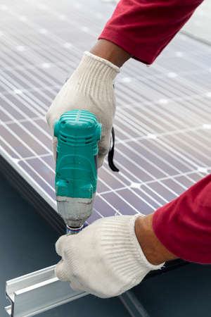 Technician installing solar panels by screwdriver, Renewable energy clean and good environment.