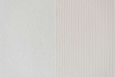Installing striped wallpaper on a concrete wall in the bedroom