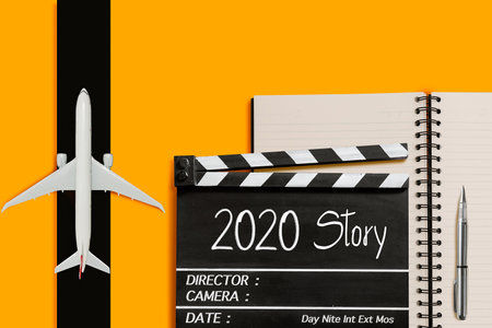 2020 story.Text title on movie clapperboard and aircraft model.の写真素材