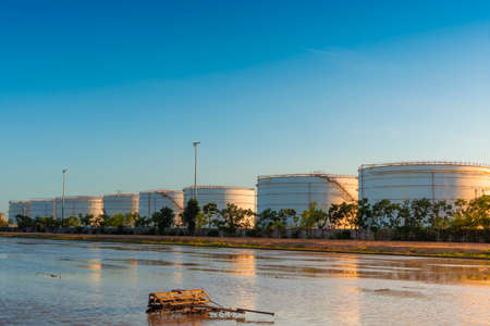 Oil field scene, Large oil storage tanks in sunsetの写真素材
