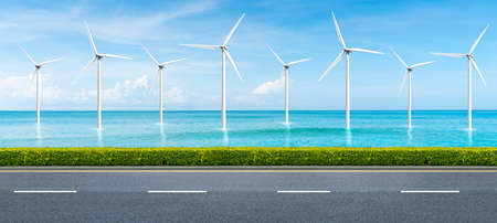 beach road and offshore windmill park in the background. clean and good environment concept