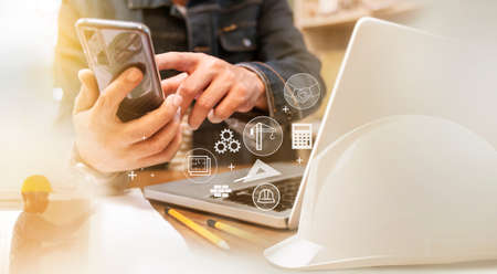 Engineer or Architect uses smartphones to meeting with suppliers. to plan construction developmentの写真素材