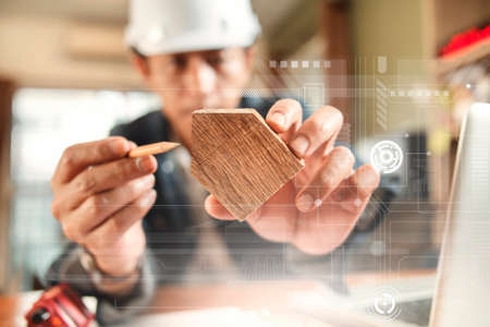 Engineer or Architect uses pencil pointing to wooden home model  for beginning construction developmentの写真素材