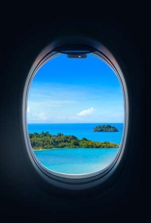 looking through the window of an airplane to the island.Summer travel destination concept.の写真素材