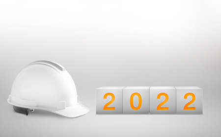 Happy New Year 2022 Construction and Industry.White Helmet and a numbered concrete cube on white...