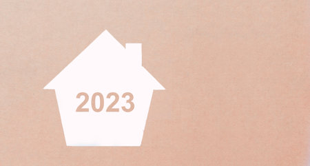 Concept of home and real estate in 2023 Coming up. By cutting paper into the shape of a house.