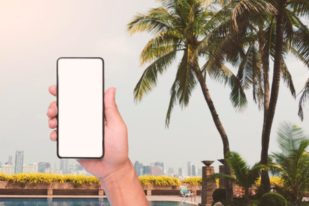 A traveler's hand holding mobile phone for searching to destination such as a hotel, restaurant or...