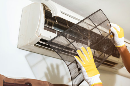 Man removing air filter in air conditioner come clean for good health at home.の写真素材