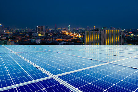 Solar panels on the roof of a tall building Send electricity to night city. sustainability energy to businesses, homes, and smart city and new generation of power. clean and enviroの写真素材