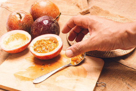 Men hands are touching a purple passion fruit in halfの写真素材