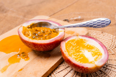 Passion fruit cut in half and spoon on cutting boardの写真素材