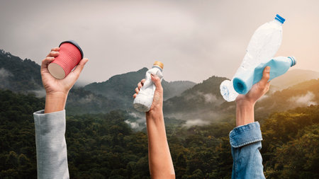 People holding various types of garbage on top of the mountain