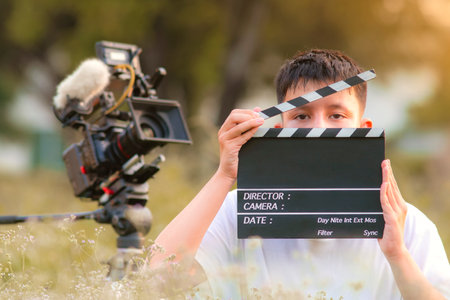 Teenage boy holding a film slate or film clapper board in the movie industry. new content creator,...