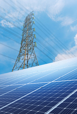 Solar panels and high-voltage tower on blue sky background.