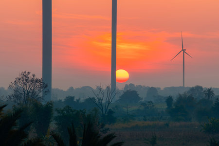 Wind turbines at sunset, an alternative energy resource from wind that can produce electricity both...