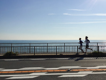 runners are jogging beside the beach in Japan at late morningのeditorial素材