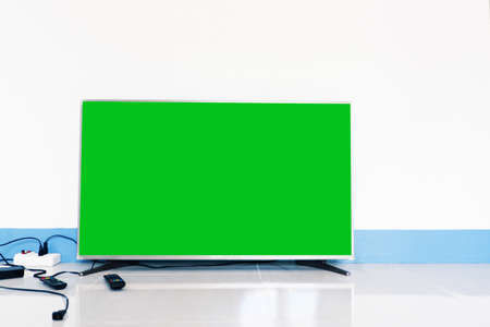 smart TV with green screen on tile floor of living room of houseの写真素材