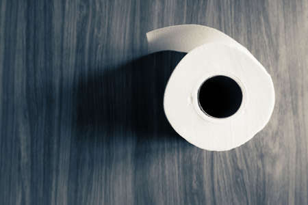 top view of Tissue roll paper on wooden table with dark toneの写真素材