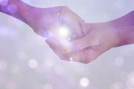 gesture of hands show giving something with white sunlight isolated on bokeh backgroundの写真素材
