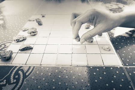 Hand of Asian woman picked the stones to play checkers.の素材 [FY310150879617]